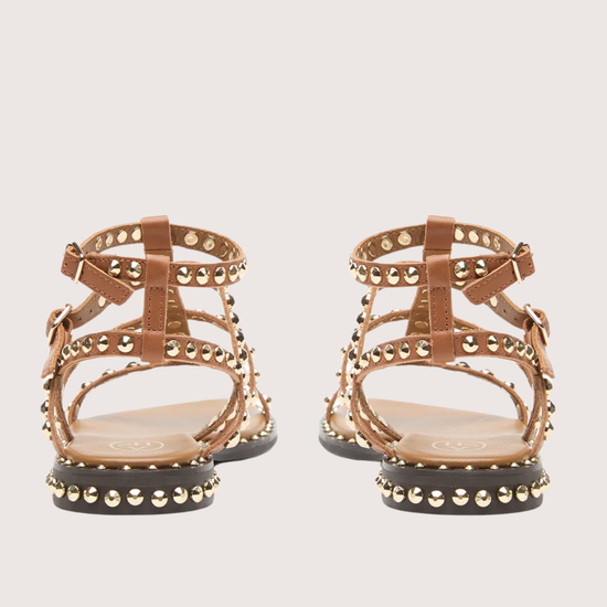 Pair of gold sandals with studded details on a white background rear view