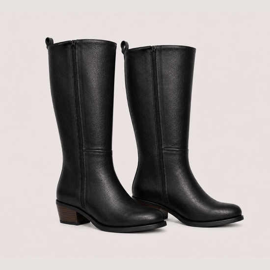 Flat lay image of two leather boots side on on a white background 