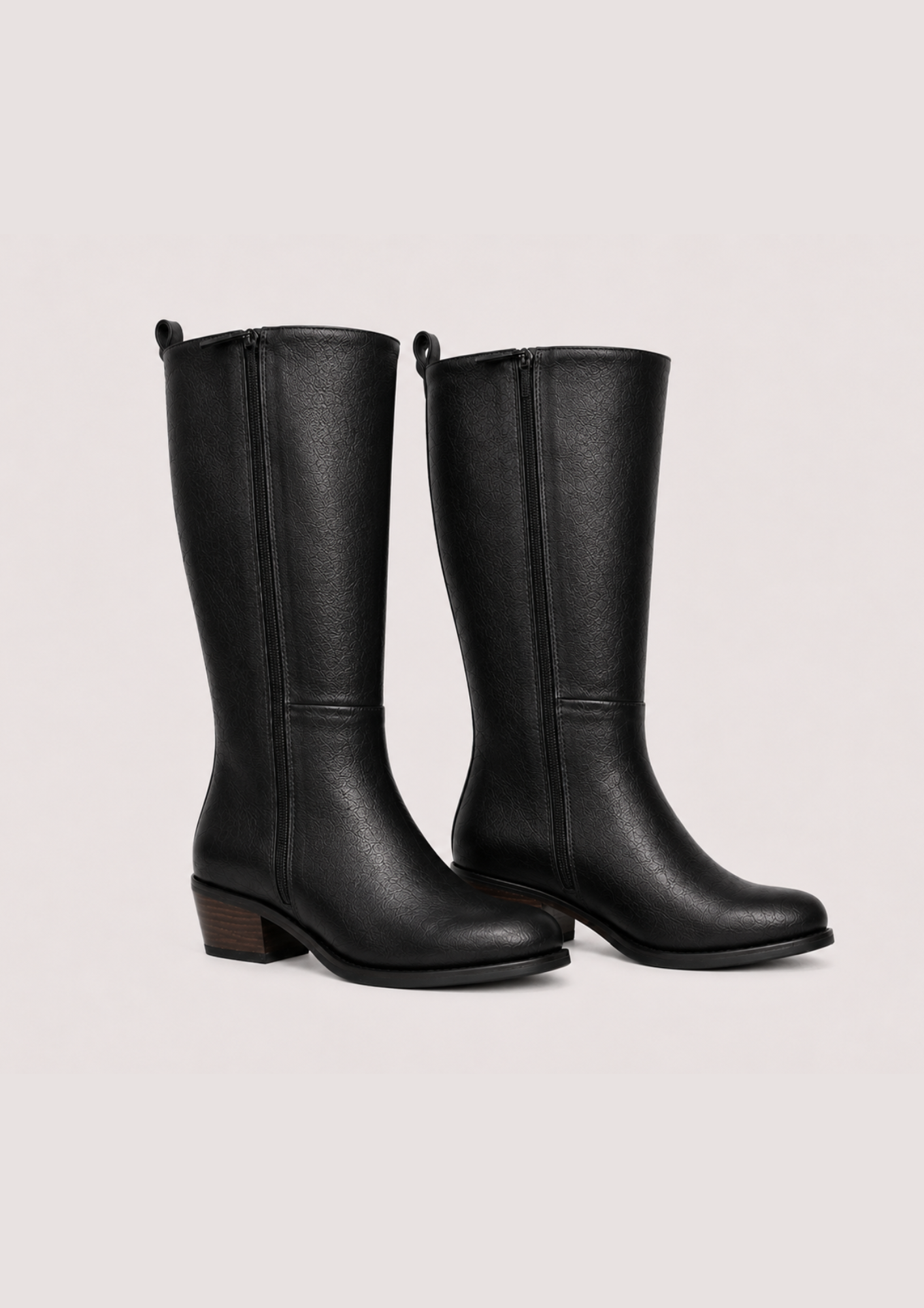 Flat lay image of two leather boots side on on a white background 