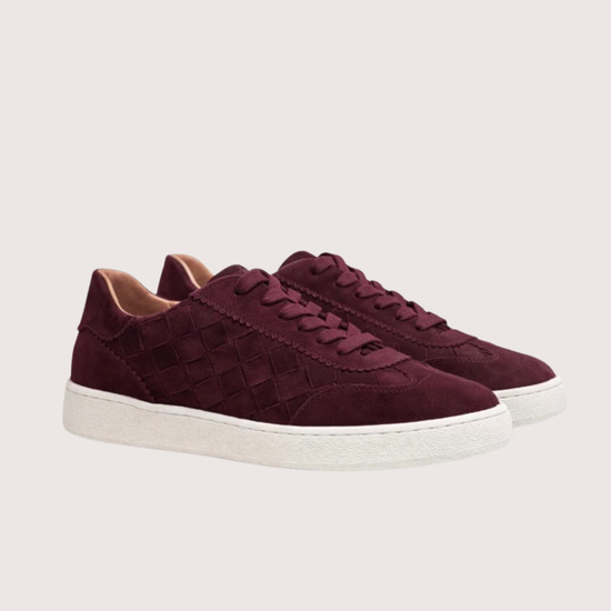 Maroon sneaker with white sole on a light gray background