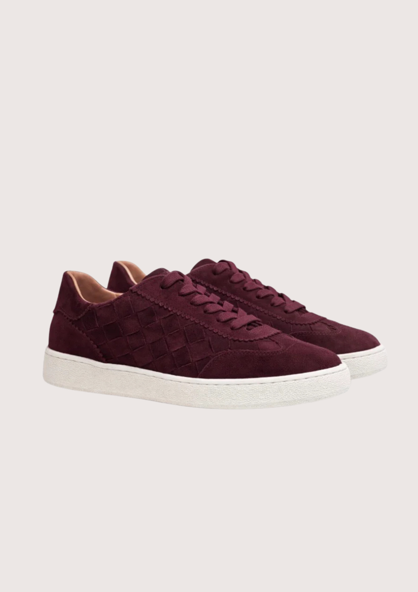 Maroon sneaker with white sole on a light gray background
