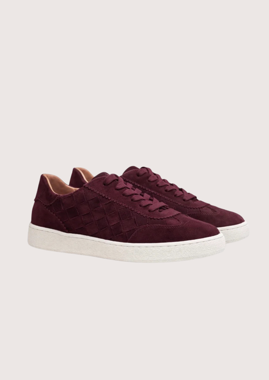 Maroon sneaker with white sole on a light gray background