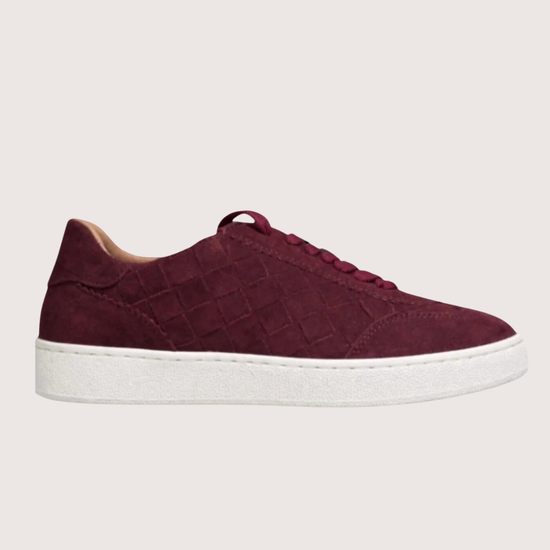 woven burgundy trainer with a white sole on a white background