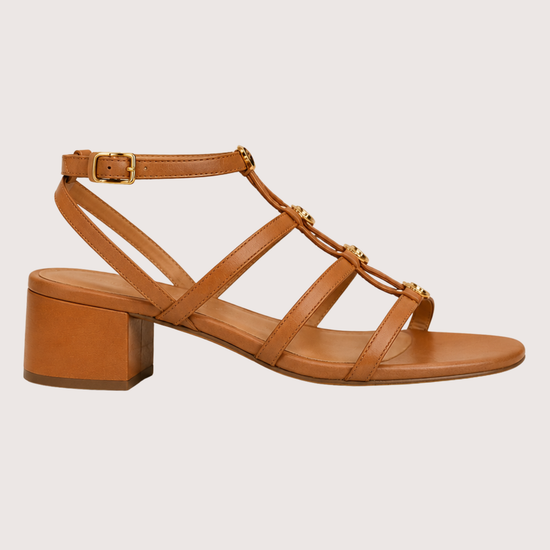 Tan sandal with a block heel on a light beige background