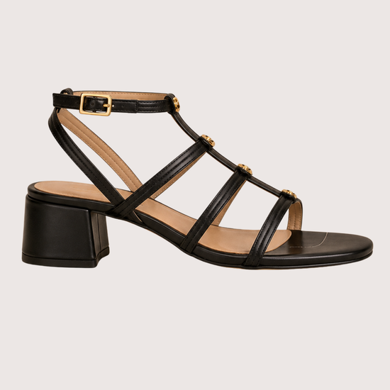 Black sandal with multiple straps on a light gray background