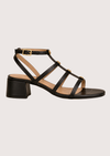 Black sandal with multiple straps on a light gray background