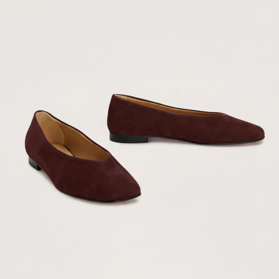 Burgundy suede flat shoe on a white background