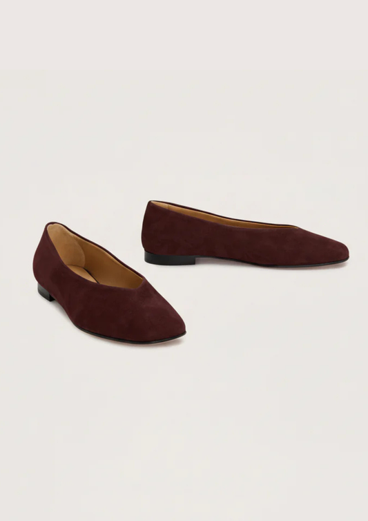 Burgundy suede flat shoe on a white background