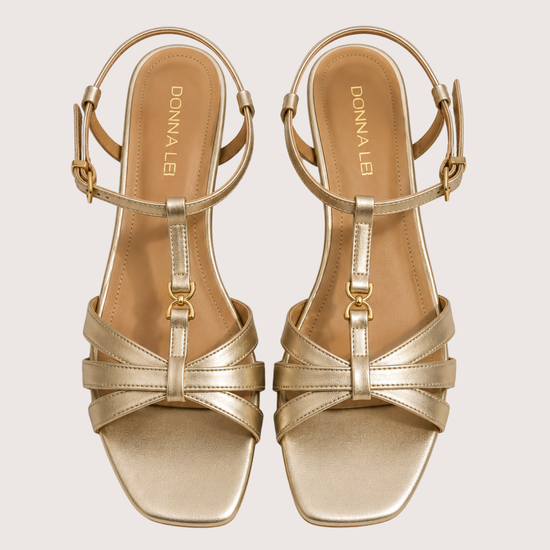 Gold sandals on a light gray background