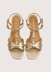 Gold sandals on a light gray background