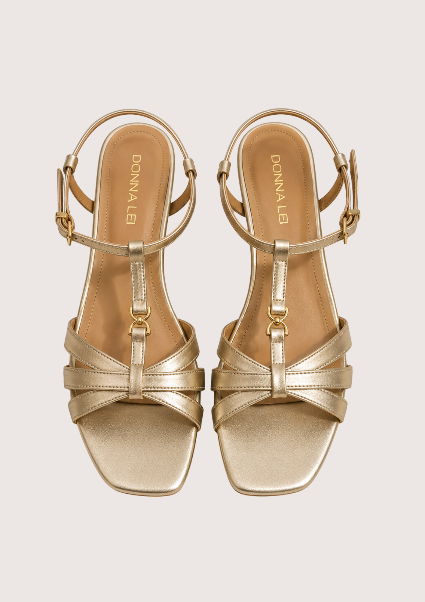 Gold sandals on a light gray background