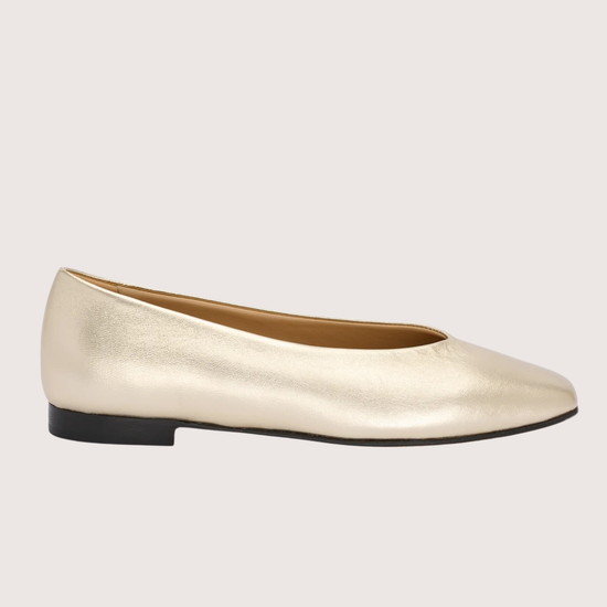 pale gold leather ballet flats on a white background