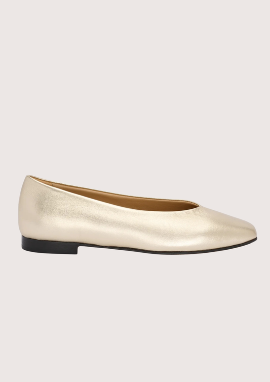 pale gold leather ballet flats on a white background