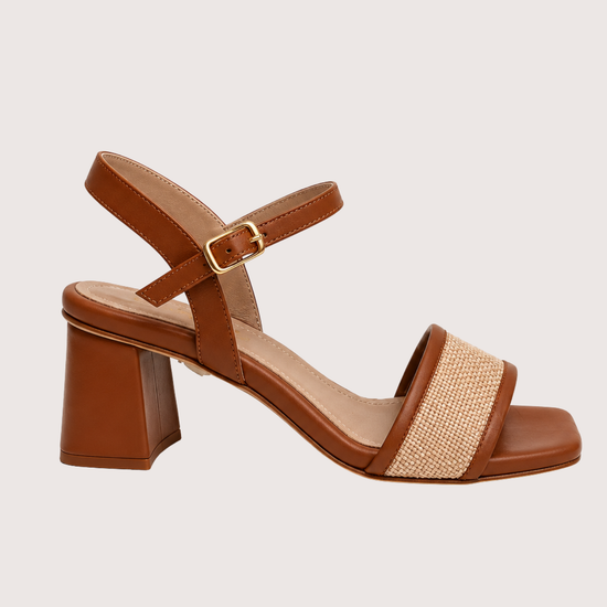 Brown sandal with block heel and woven strap on a light gray background
