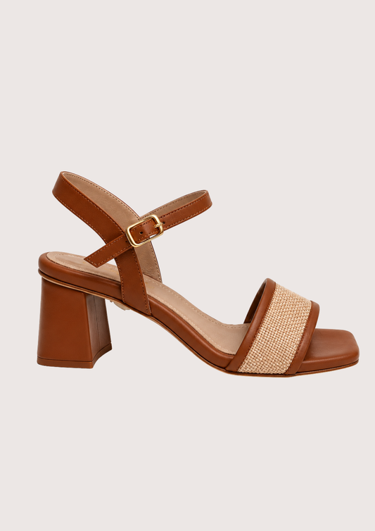 Brown sandal with block heel and woven strap on a light gray background