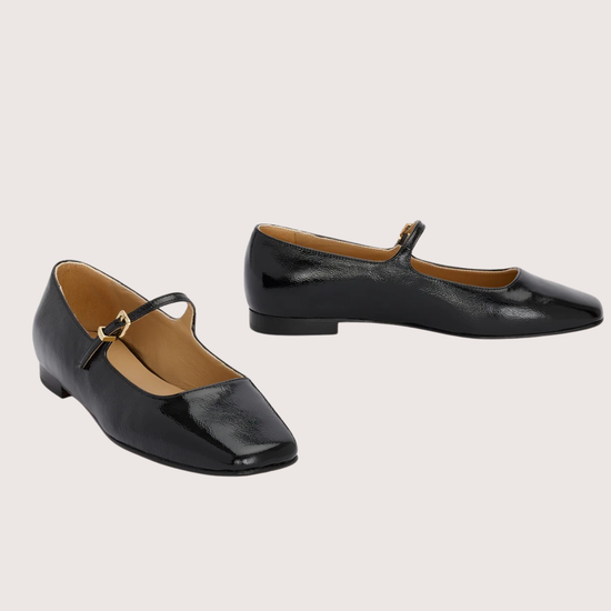 Pair of black patent leather shoes with a square toe on a light gray background