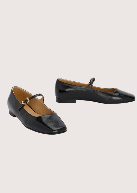 Pair of black patent leather shoes with a square toe on a light gray background