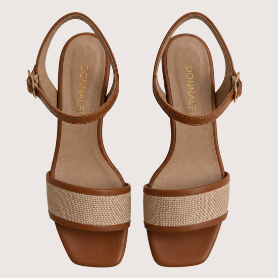 Pair of brown sandals with woven detailing on a light gray background