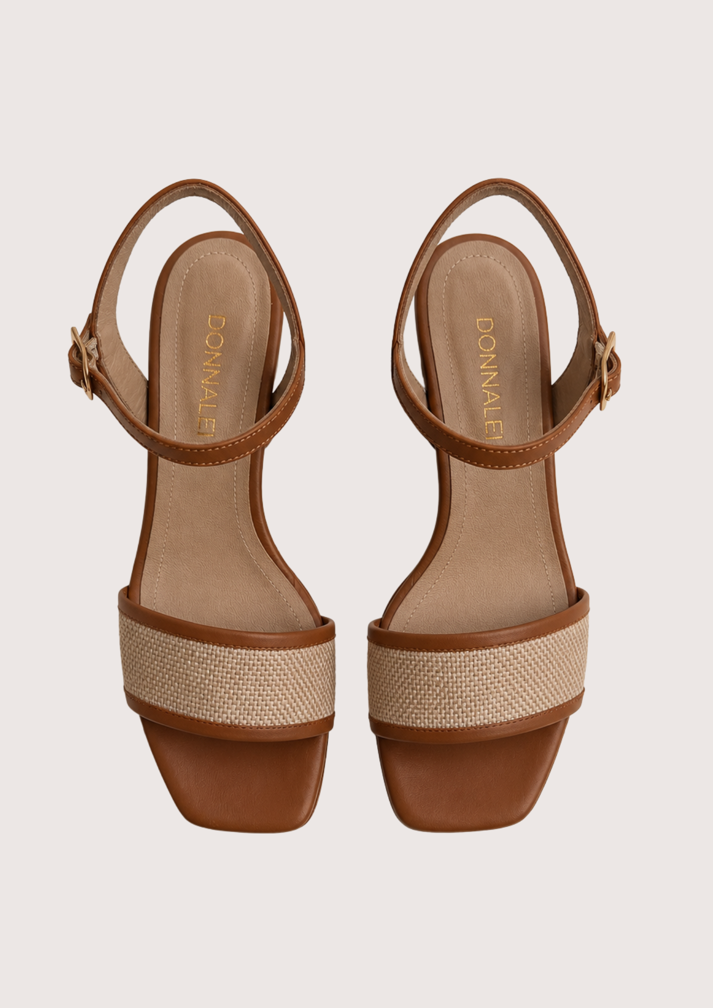Pair of brown sandals with woven detailing on a light gray background