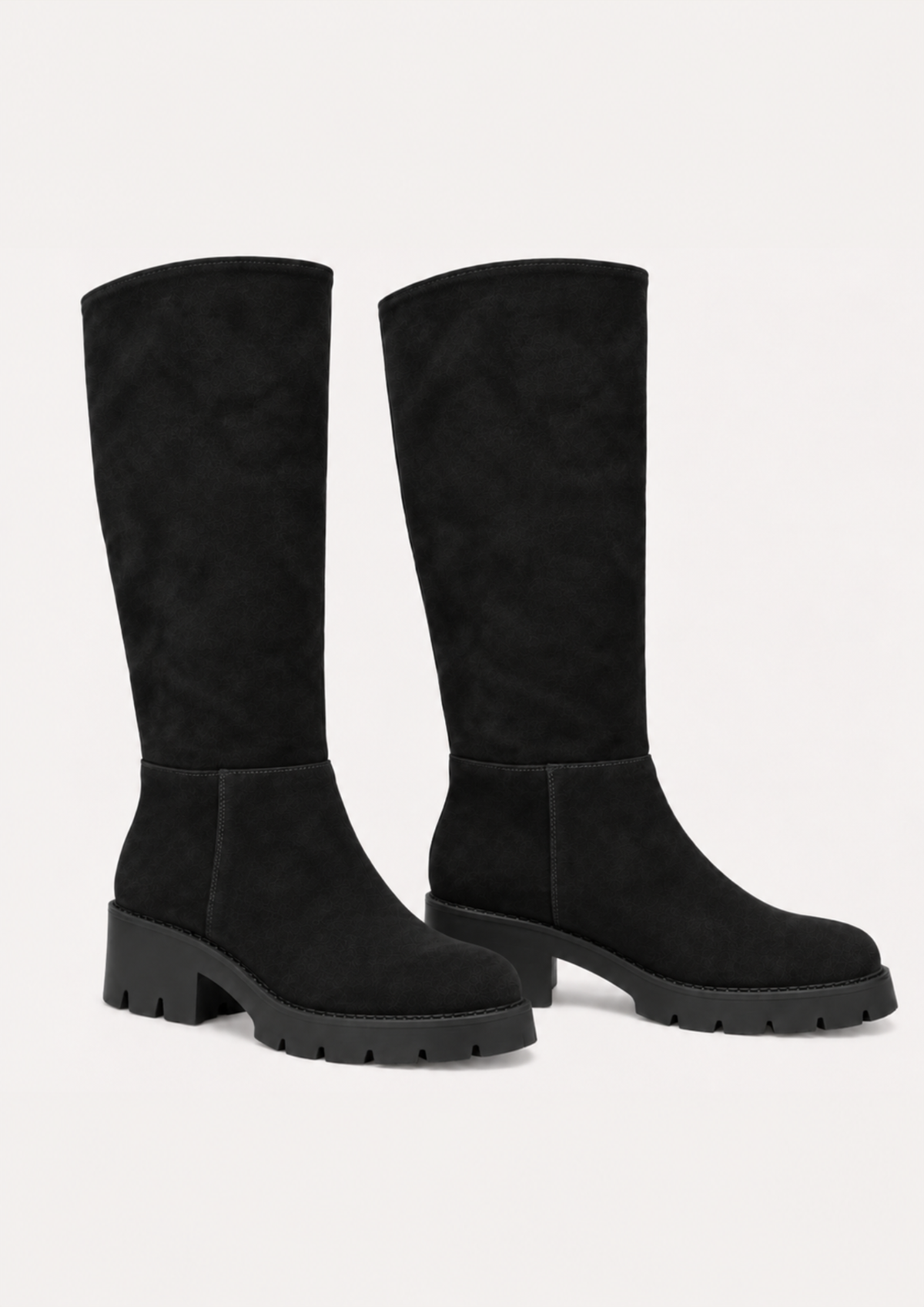 A pair of black knee-high suede boots with chunky lug soles and block heels, shown against a plain off-white background.