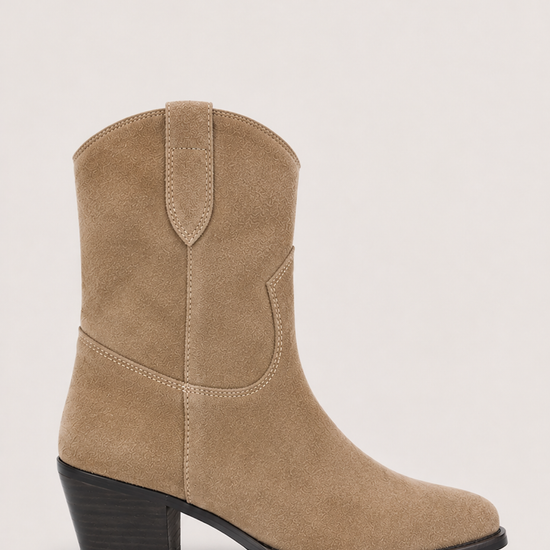 A single mid-calf western-style boot in beige suede with a black block heel and black outsole, shown from a side profile against a light gray background.
