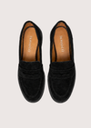 Black suede loafer on a plain grey background.