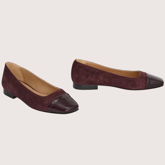 Pair of burgundy suede shoes on a light gray background