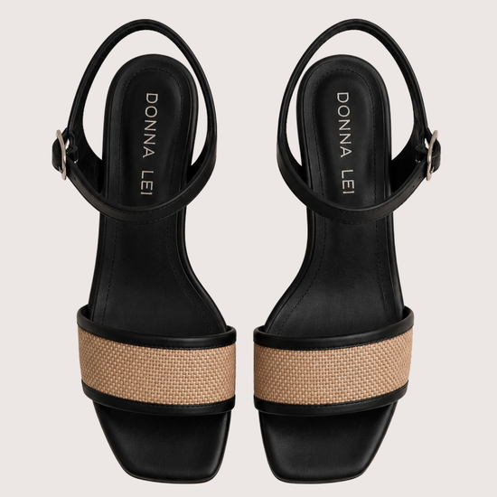 Black sandals with raffia across the toe on a white background