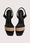 Black sandals with raffia across the toe on a white background