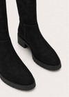 Black suede over-the-knee boots with chunky lug soles, shown from a close-up angle on a light gray background.