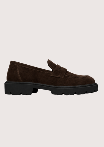 Brown suede loafer with a black sole on a light grey background