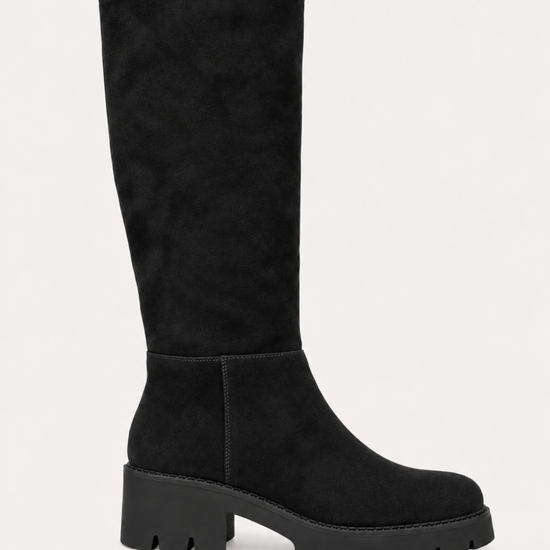 A single black suede knee-high boot with a chunky lug sole and block heel, shown in profile against a light off-white background.