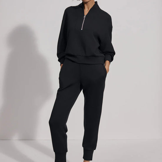 Quarter zip and slightly cropped black sweat top with shawl collar and V necklin