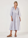 Woman wearing a light blue dress by Mondo Corsini on a white background