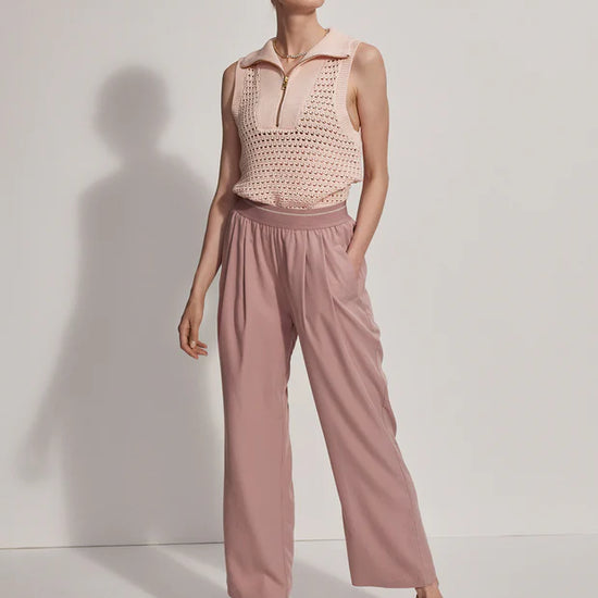 Pink pull on trousers with an elasticated waistband and side pockets model shot