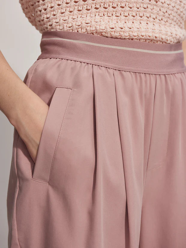 Pink pull on trousers with an elasticated waistband and side pockets close up of waistband