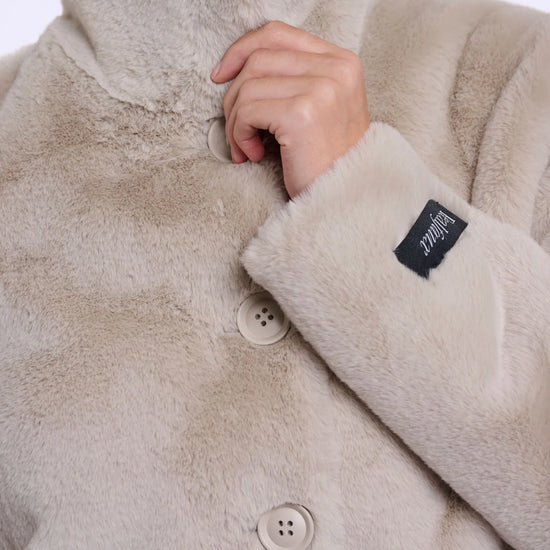 Close-up of a beige fleece jacket with buttons and a brand label.