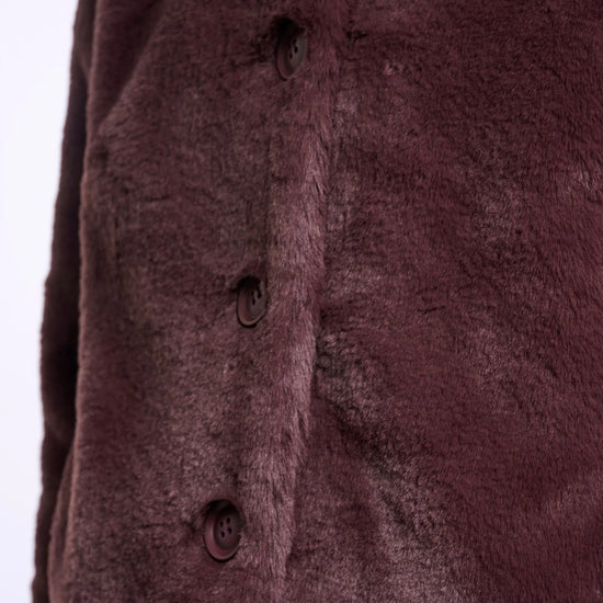 Close-up of a textured brown fabric with buttons on a white background