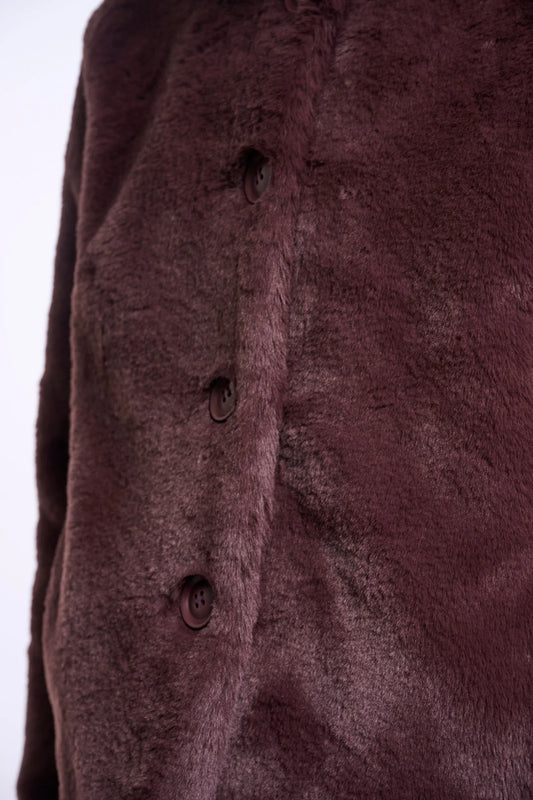 Close-up of a textured brown fabric with buttons on a white background