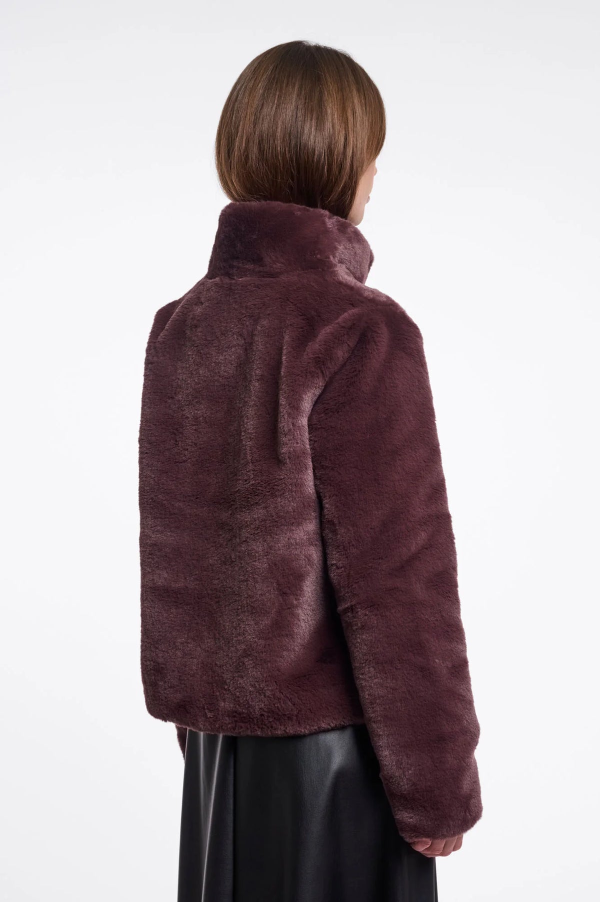 Person wearing a burgundy faux fur jacket on a white background