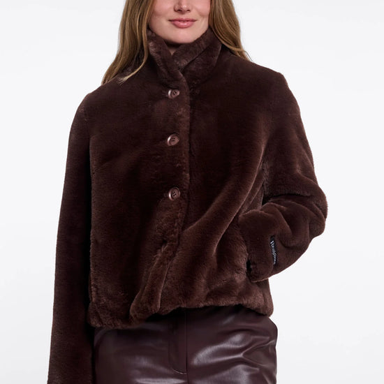Woman wearing a brown fur coat on a white background