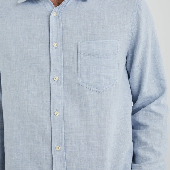 light blue shirt with chest pocket and curved hem close up
