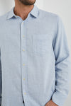 light blue shirt with chest pocket and curved hem close up
