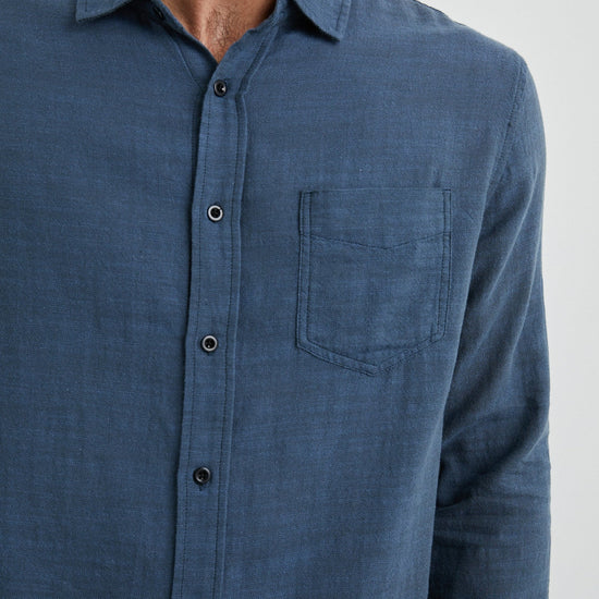 blue shirt with chest pocket and curved hem  close up