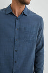 blue shirt with chest pocket and curved hem  close up