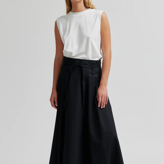 model wearing black skirt and white top