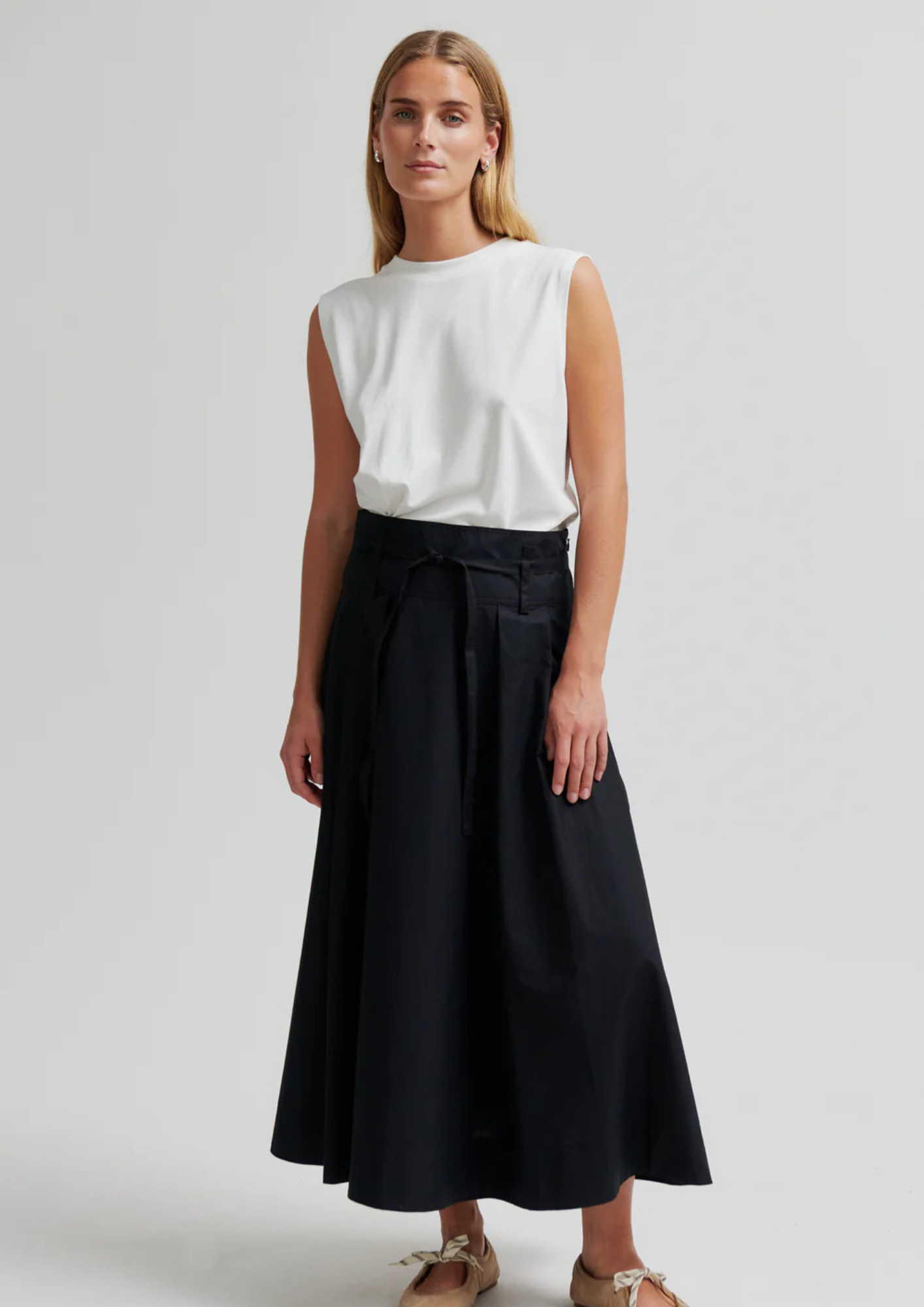 model wearing black skirt and white top