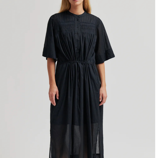 model wearing black dress on plain background