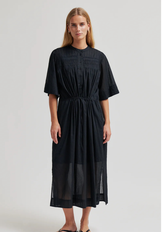 model wearing black dress on plain background