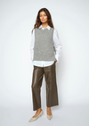 A woman modeling a gray knit sweater vest over a white collared shirt, paired with brown wide-leg cropped pants and beige pointed-toe heels, against a light gray studio background.